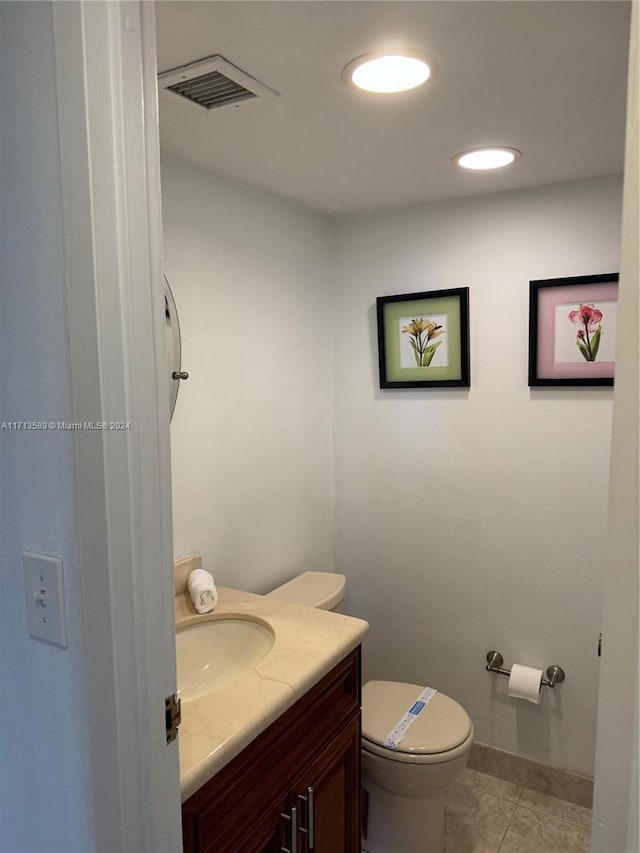 bathroom featuring tile patterned flooring, vanity, and toilet