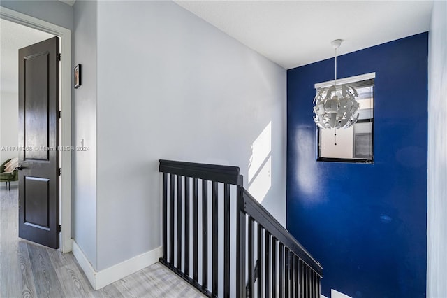 stairway featuring hardwood / wood-style floors and a notable chandelier