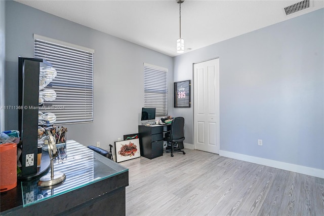 home office with light hardwood / wood-style flooring