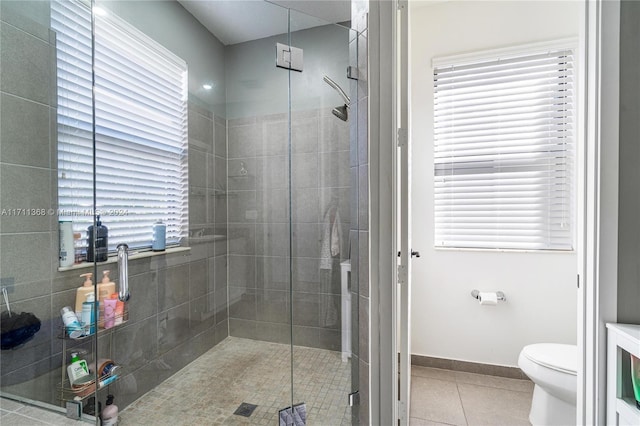 bathroom featuring tile patterned floors, toilet, and walk in shower