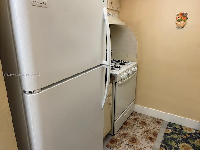 kitchen featuring light tile patterned floors, white appliances, and custom exhaust hood