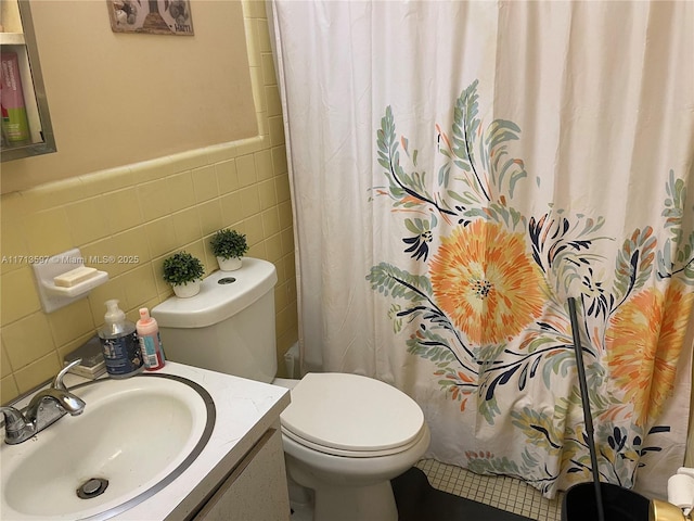 bathroom featuring a shower with shower curtain, vanity, toilet, and tile walls