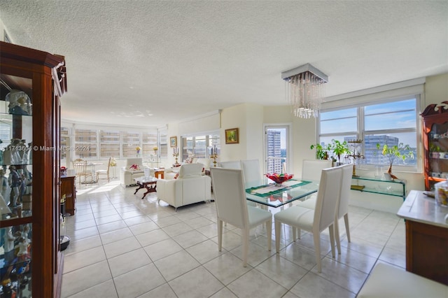 dining room featuring a textured ceiling, an inviting chandelier, and light tile patterned flooring