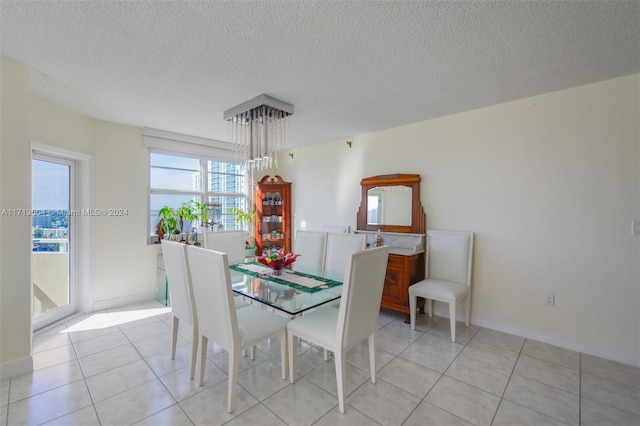 dining area featuring light tile patterned floors and a textured ceiling