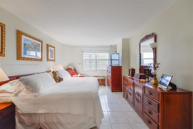 bedroom featuring light tile patterned flooring and a textured ceiling