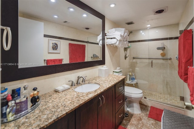 bathroom with vanity, toilet, and a shower with door