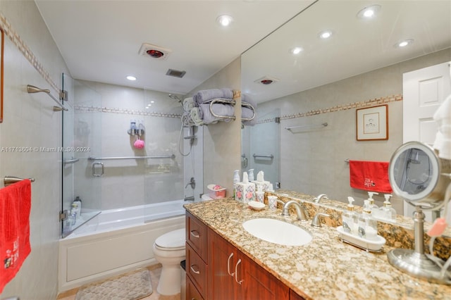 full bathroom with tile patterned flooring, vanity, toilet, and shower / bath combination with glass door