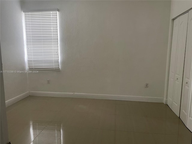 unfurnished bedroom featuring tile patterned floors and a closet