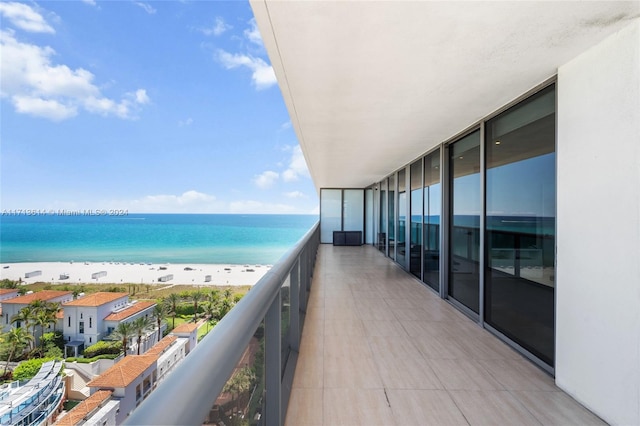 balcony with a water view and a beach view