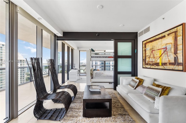 living room featuring a wall of windows and light tile patterned floors