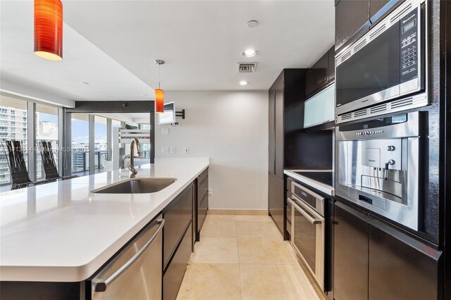 kitchen with backsplash, decorative light fixtures, sink, and black appliances