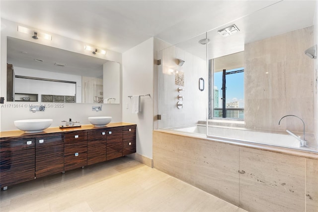 bathroom featuring tiled shower / bath and vanity