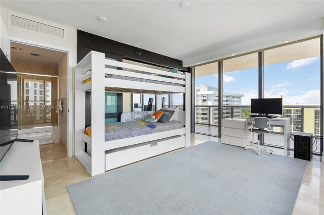 bedroom featuring light tile patterned floors, expansive windows, and access to outside