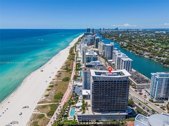 bird's eye view featuring a water view and a beach view