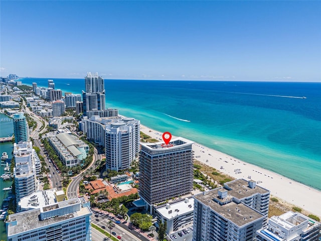 bird's eye view with a water view and a beach view