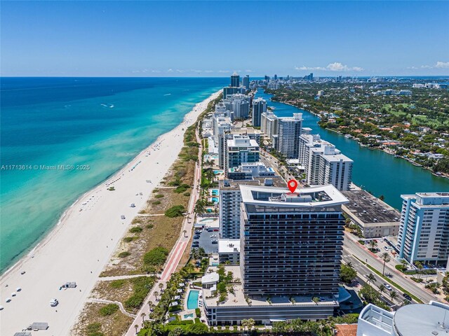 birds eye view of property with a water view and a view of the beach