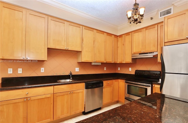 kitchen featuring appliances with stainless steel finishes, a sink, light brown cabinets, under cabinet range hood, and visible vents