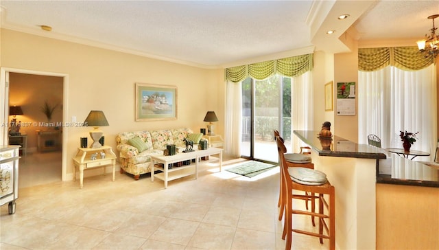 living area featuring ornamental molding, a textured ceiling, light tile patterned floors, and a chandelier