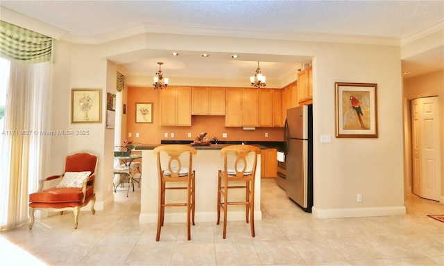 kitchen with a chandelier, a center island, stainless steel fridge, and decorative light fixtures