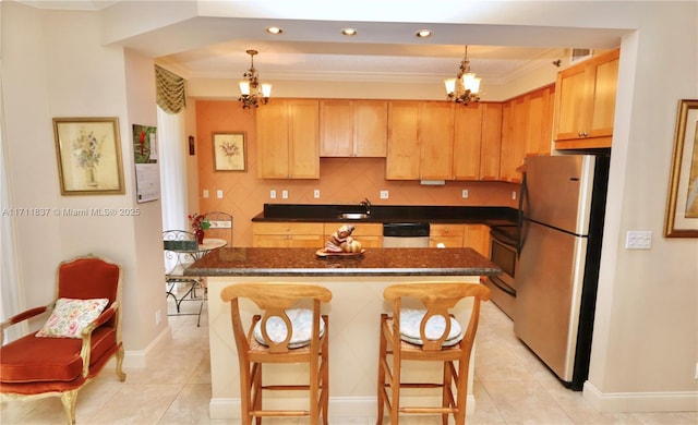kitchen with crown molding, dark countertops, a chandelier, a sink, and stainless steel appliances