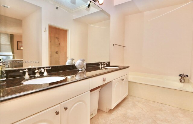 full bath featuring a sink, a bath, tile patterned flooring, and double vanity