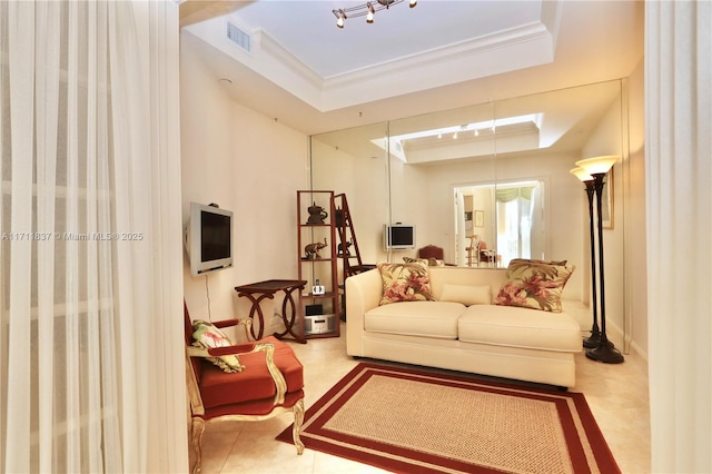 interior space with visible vents, crown molding, baseboards, tile patterned floors, and a tray ceiling