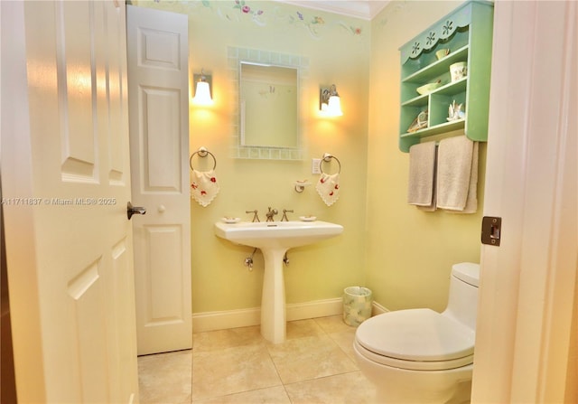 half bathroom featuring tile patterned flooring, baseboards, and toilet