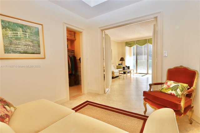 living area with baseboards and light tile patterned floors