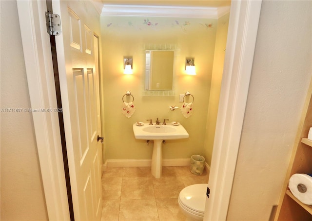 bathroom with tile patterned flooring, baseboards, crown molding, and toilet