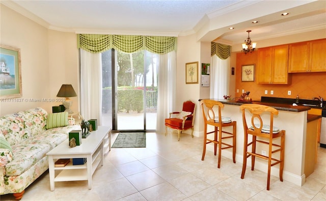 kitchen featuring hanging light fixtures, crown molding, a kitchen breakfast bar, and decorative backsplash