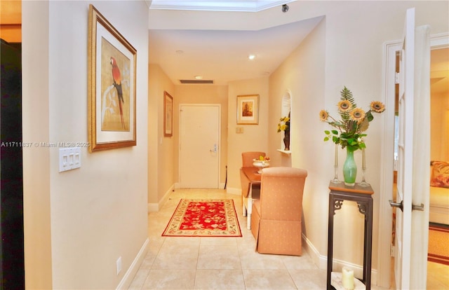 corridor featuring light tile patterned flooring, baseboards, and visible vents