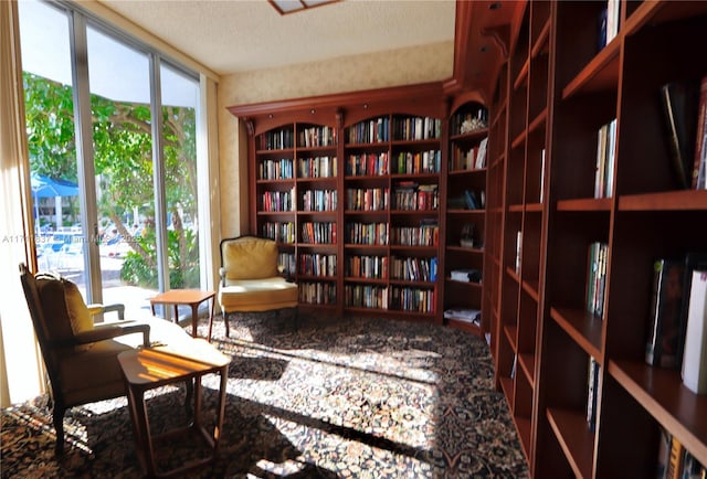 sitting room featuring bookshelves and a textured ceiling