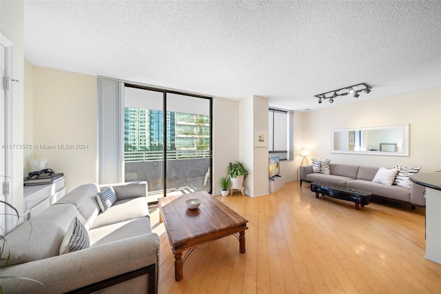 living room featuring a textured ceiling, light hardwood / wood-style flooring, and sink