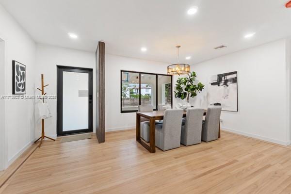 dining space featuring an inviting chandelier and light hardwood / wood-style flooring