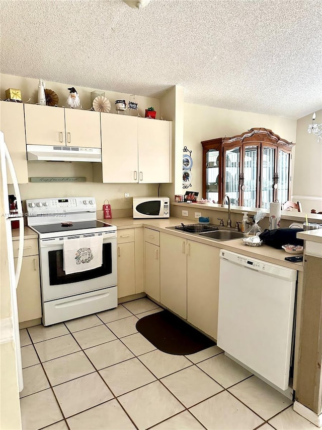 kitchen featuring sink, a chandelier, a textured ceiling, white appliances, and light tile patterned flooring