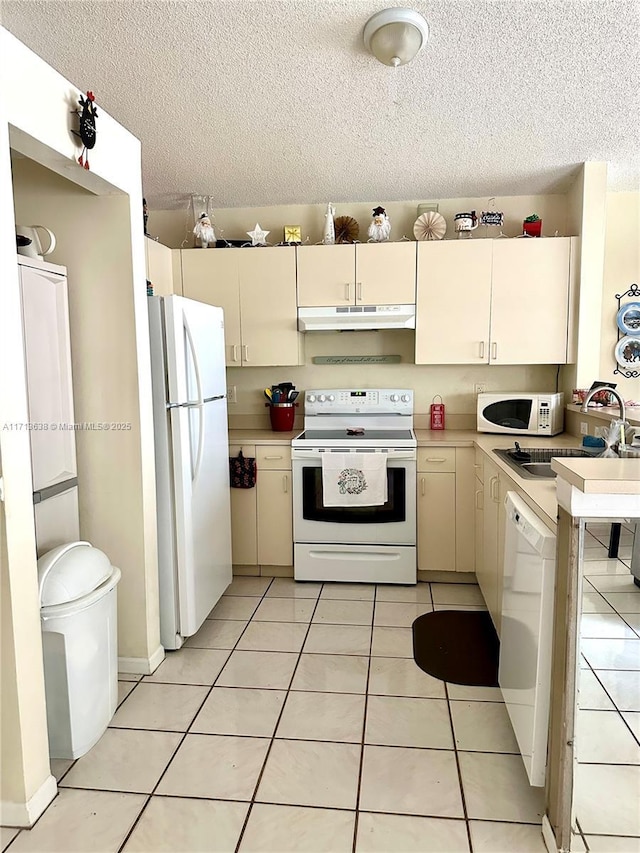 kitchen featuring light tile patterned floors, white appliances, sink, and washer / clothes dryer