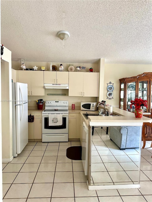 kitchen with kitchen peninsula, light tile patterned floors, white appliances, and sink