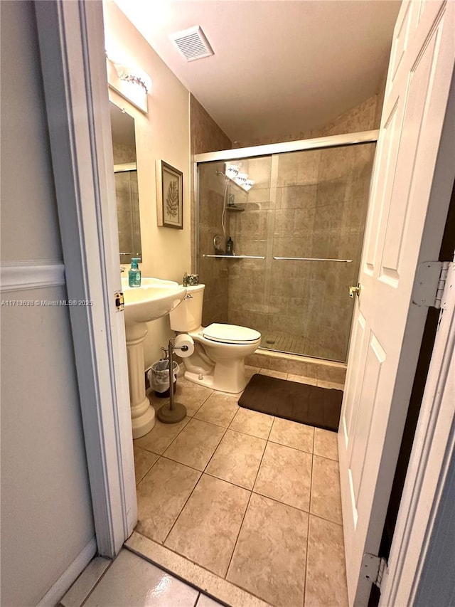 bathroom with tile patterned flooring, toilet, and walk in shower