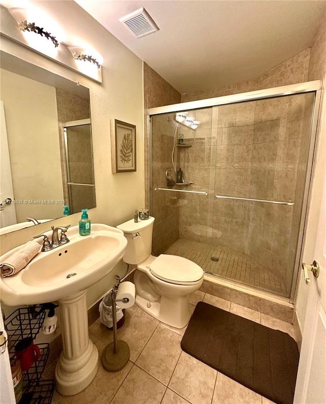 bathroom featuring walk in shower, tile patterned flooring, and toilet