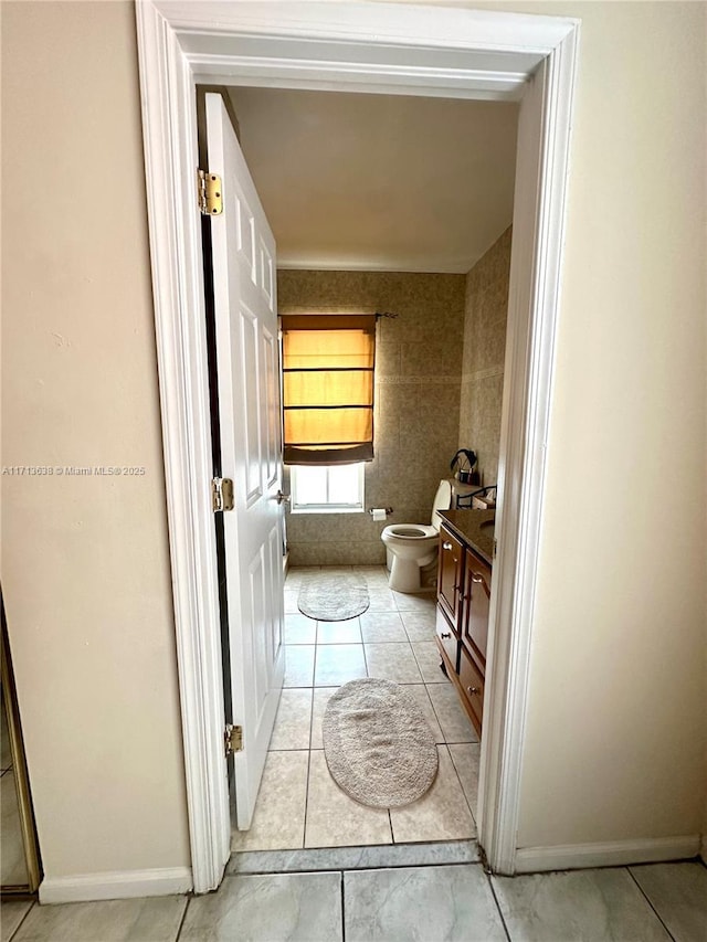 bathroom with tile patterned flooring, vanity, and toilet