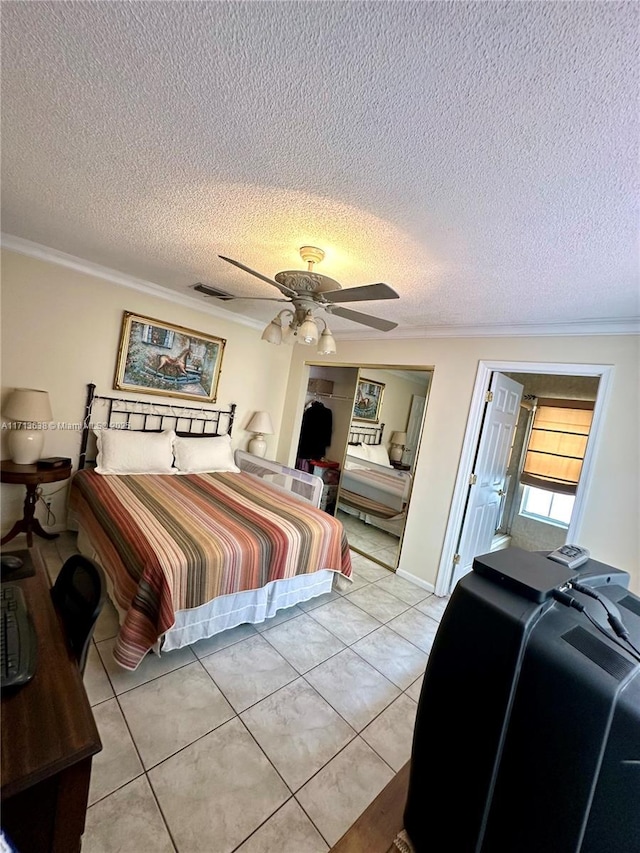 tiled bedroom featuring a textured ceiling, ceiling fan, and ornamental molding