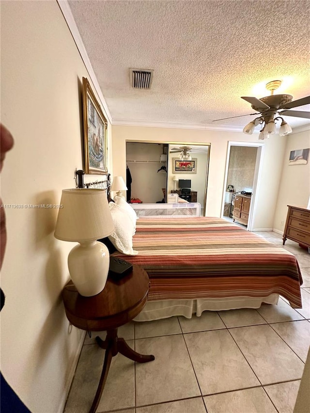 bedroom featuring light tile patterned floors, a textured ceiling, and ceiling fan