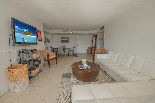 living room featuring light tile patterned flooring and a textured ceiling