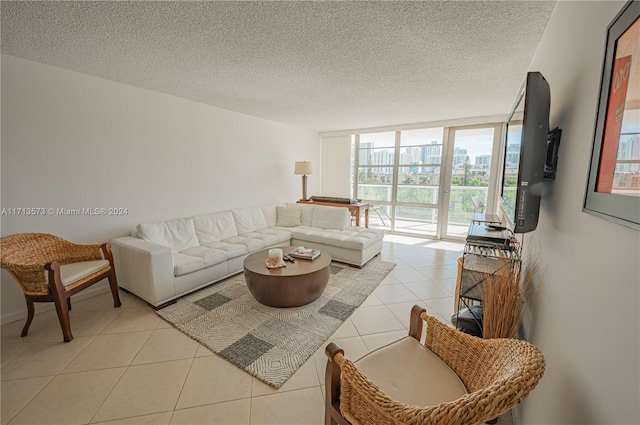 living room with expansive windows, light tile patterned floors, and a textured ceiling