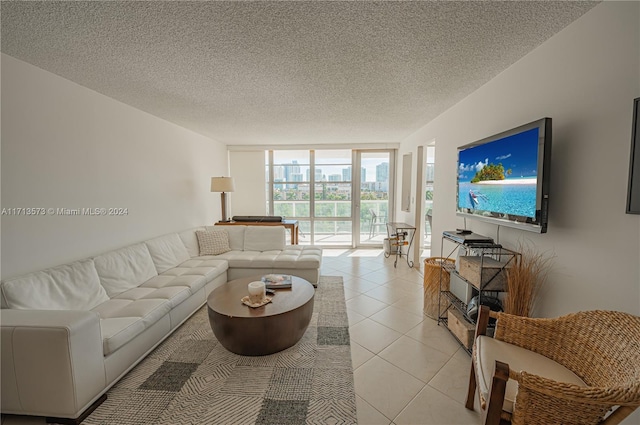 living room with expansive windows, light tile patterned floors, and a textured ceiling