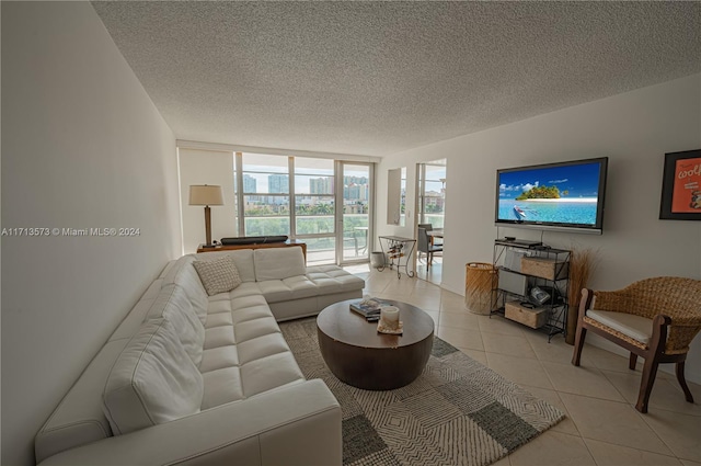 living room featuring expansive windows, light tile patterned flooring, and a textured ceiling