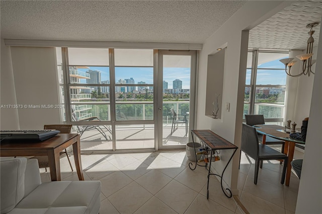 entryway with a water view, floor to ceiling windows, light tile patterned floors, and a textured ceiling