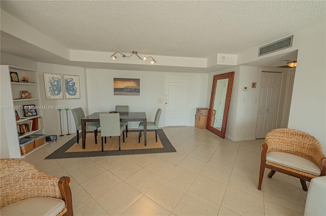 dining room with built in features, a textured ceiling, and light tile patterned floors