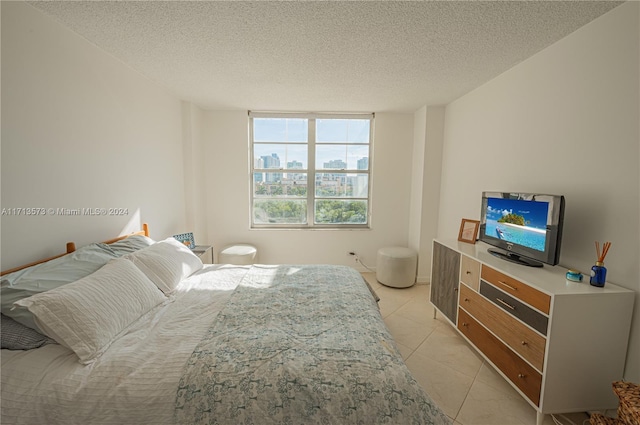 bedroom featuring light tile patterned floors and a textured ceiling