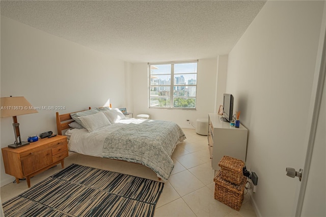 bedroom with light tile patterned floors and a textured ceiling